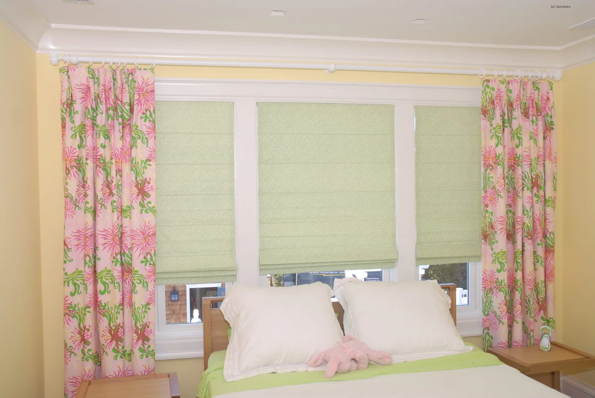 Roman shades and drapery side panels made from the client's own fabric in a Spring Lake bedroom
