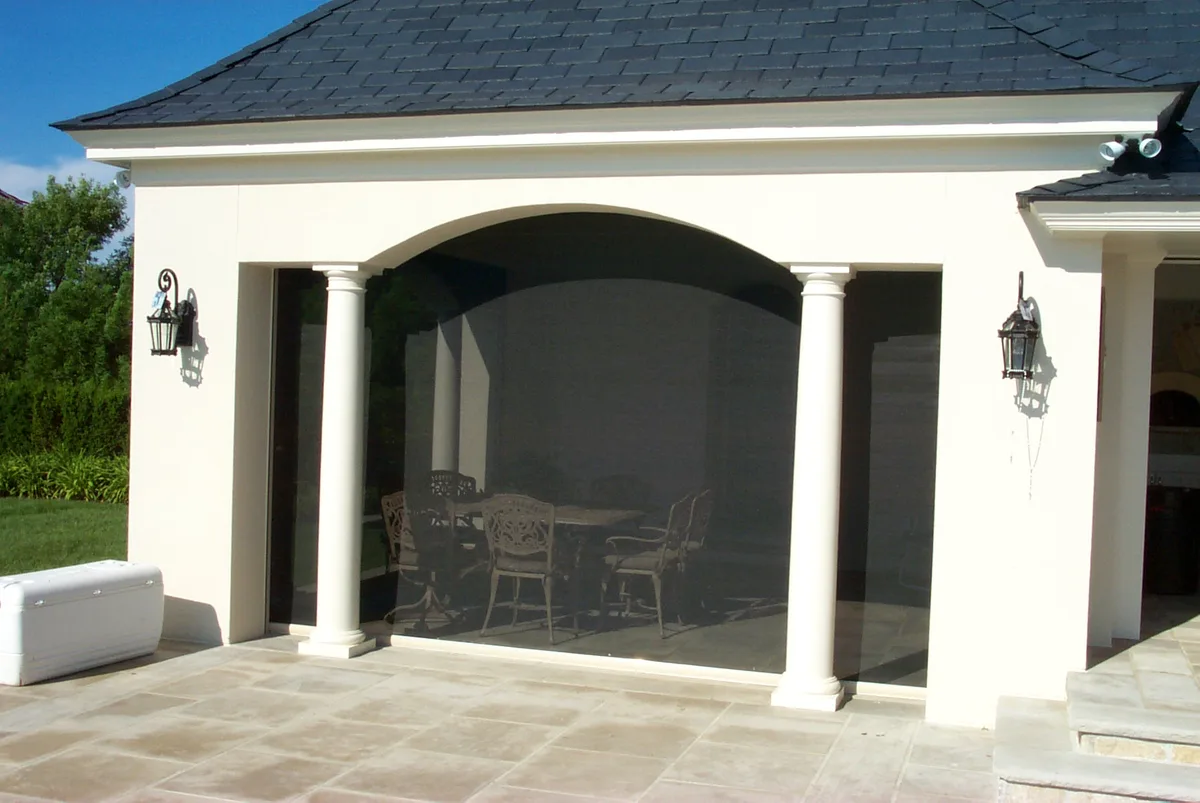 Exterior bug-screen roller shade on a Rumson pool house
