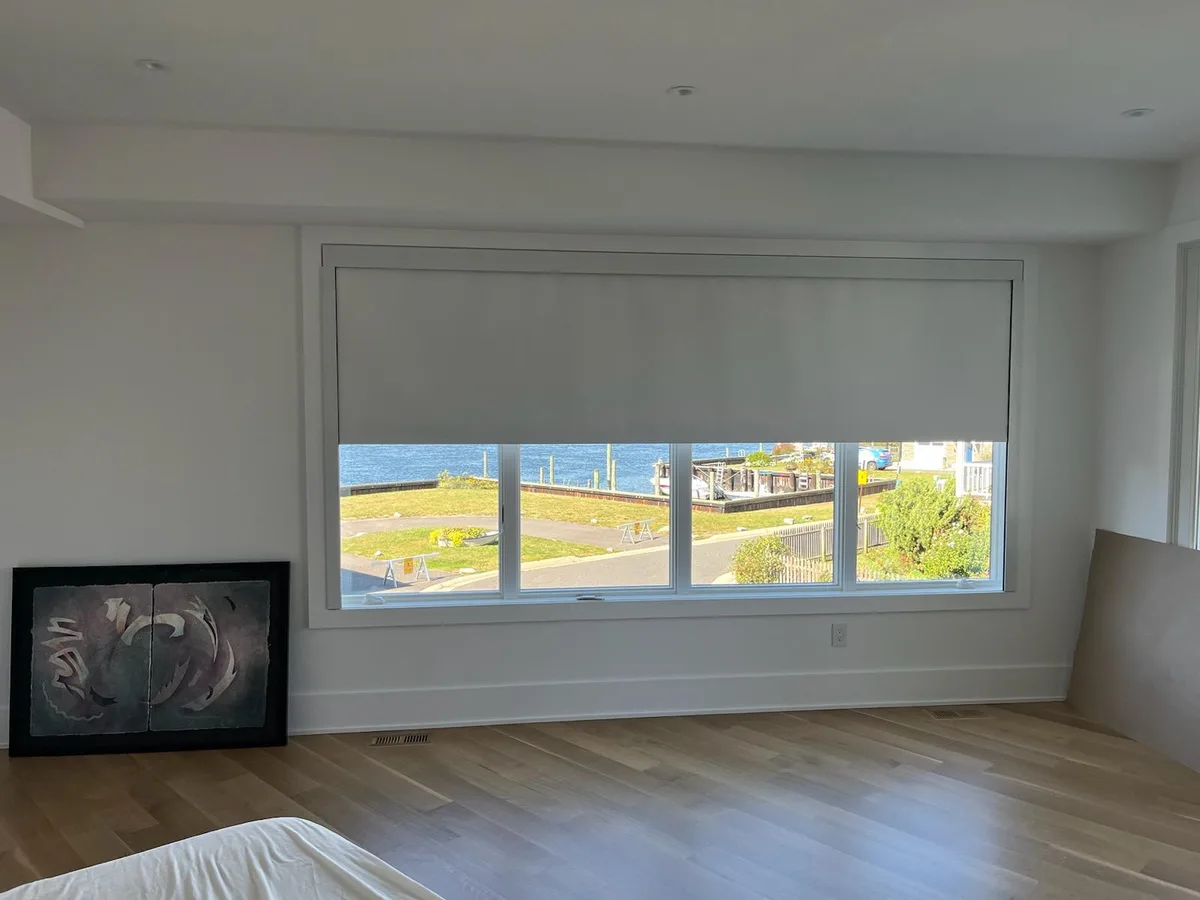 Lutron motorized blackout roller shade with side channels in a Long Branch home