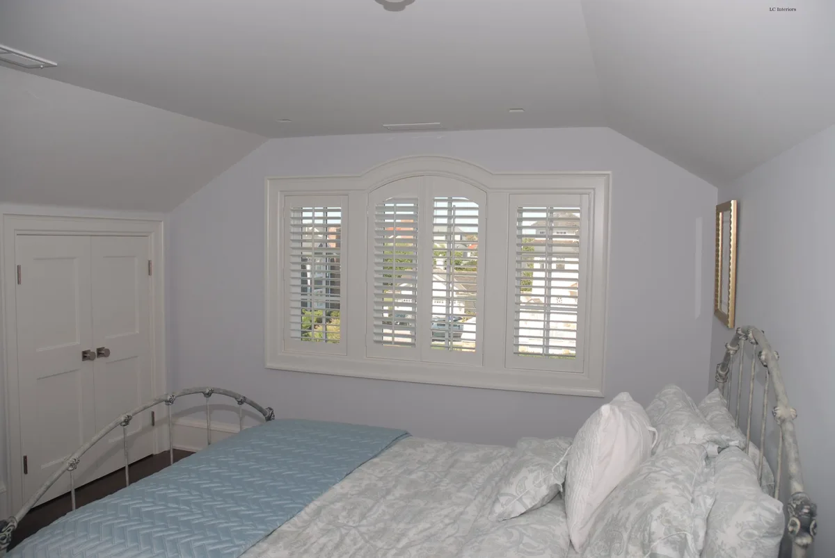 Arch-top plantation shutters in a Spring Lake bedroom